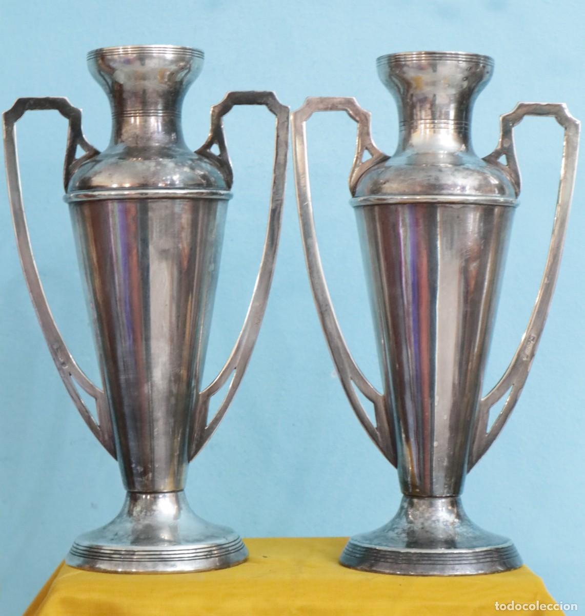 Antig&uuml;edades: Jarrones de altar elaborados en metal plateado. Meneses. Pps. S. XX. Miden 26 cm de altura.