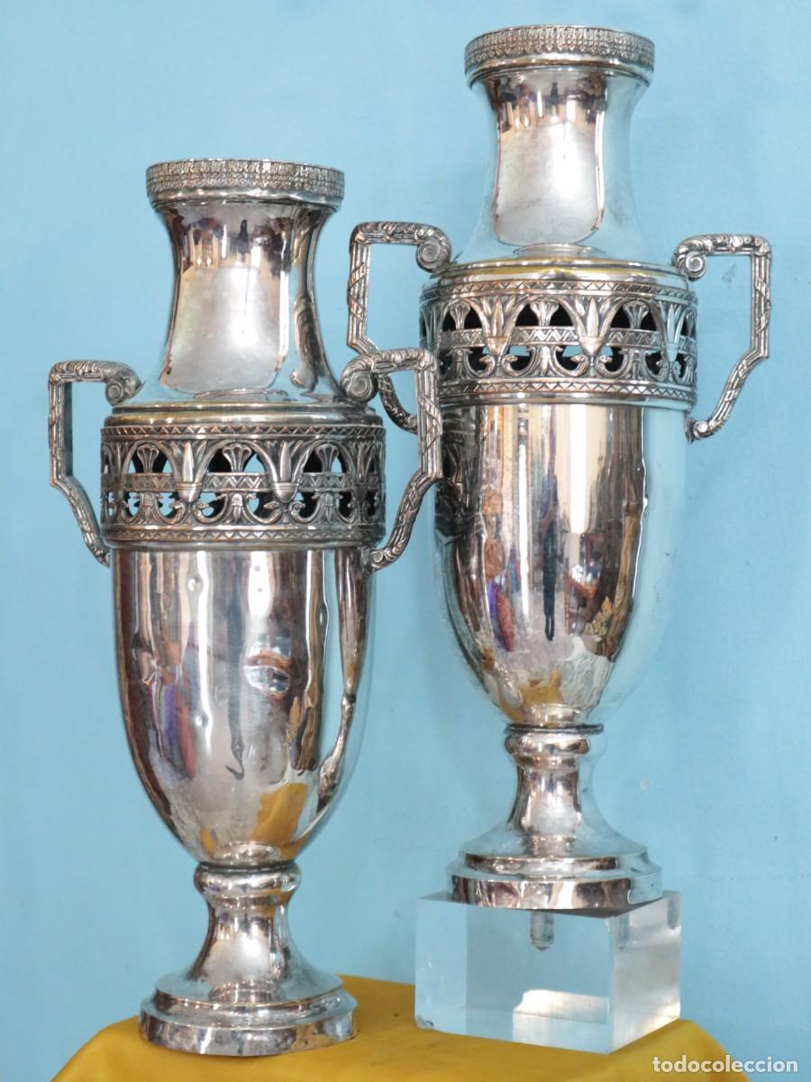 Antig&uuml;edades: Jarrones o &aacute;nforas de altar elaborados en metal plateado. Pps. S. XX. Miden 40 cm de altura.