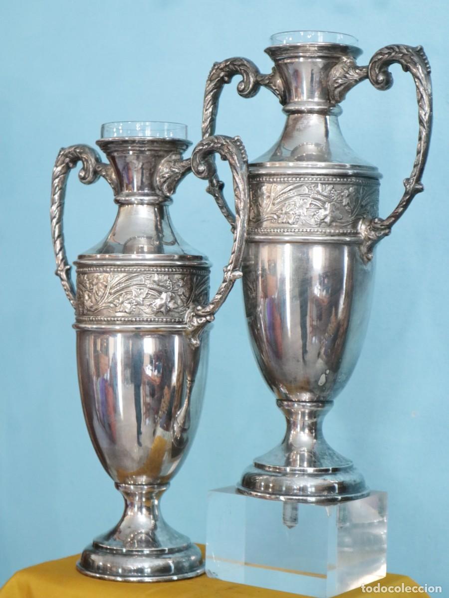 Antig&uuml;edades: Jarrones o &aacute;nforas de altar elaborados en metal plateado. Pps. S. XX. Miden 32cm de altura.