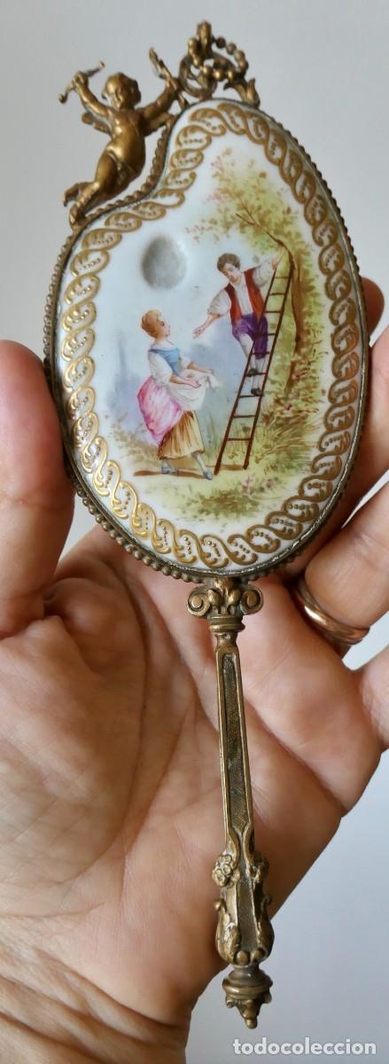 Antig&uuml;edades: Espejo de mano en miniatura de porcelana de con montura de bronce o metal dorado