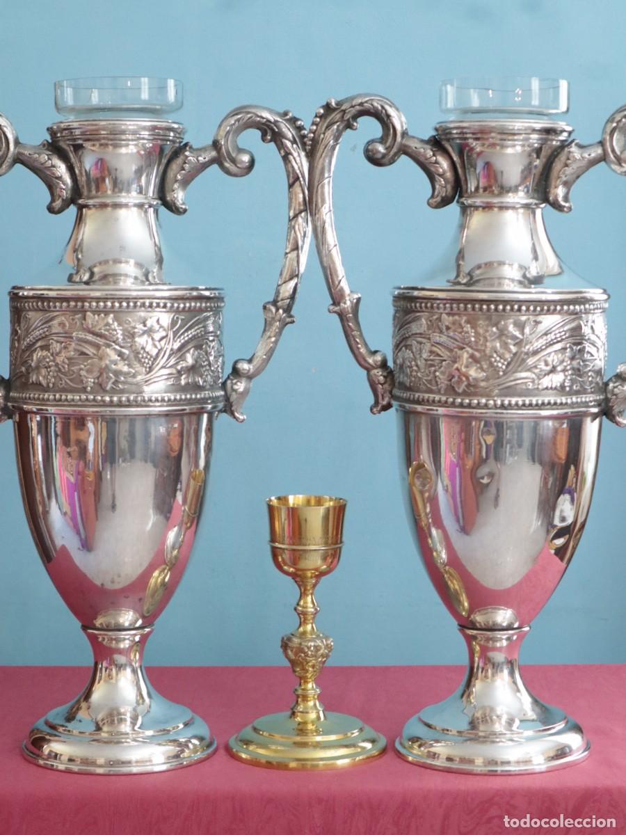 Antig&uuml;edades: Grandes jarrones o &aacute;nforas de altar elaborados en metal plateado. Pps. S. XX. Miden 57 cm de altura.