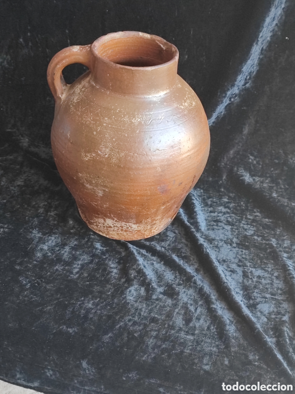 Antig&uuml;edades: Este c&aacute;ntaro de barro tradicional, caracterizado por su forma abombada y asa lateral, se asemeja a l