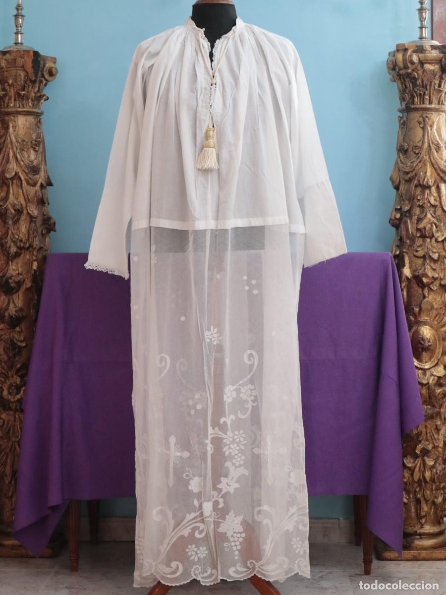 Antig&uuml;edades: Liviana alba confeccionada en hilo de lino y encajes manuales con motivos religiosos. Pps. S XX
