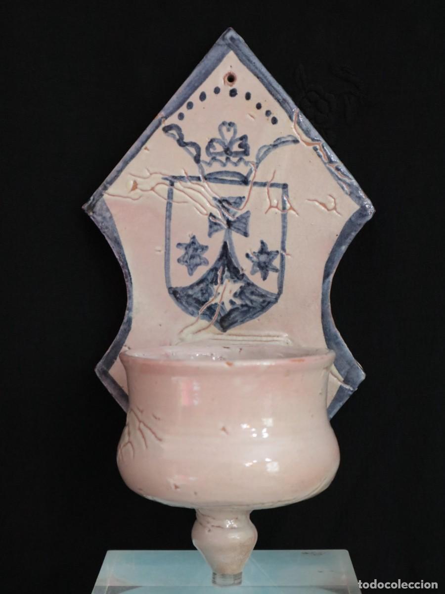 Antig&uuml;edades: Benditera de cer&aacute;mica portando el Escudo Carmelita. Teruel, siglo XVIII. Mide 22 cm de altura.