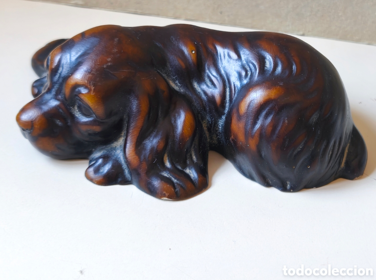 Antig&uuml;edades: Cocker Spaniel en posici&oacute;n de descanso. Material: Por su acabado y brillo, parece ser de baquelita.