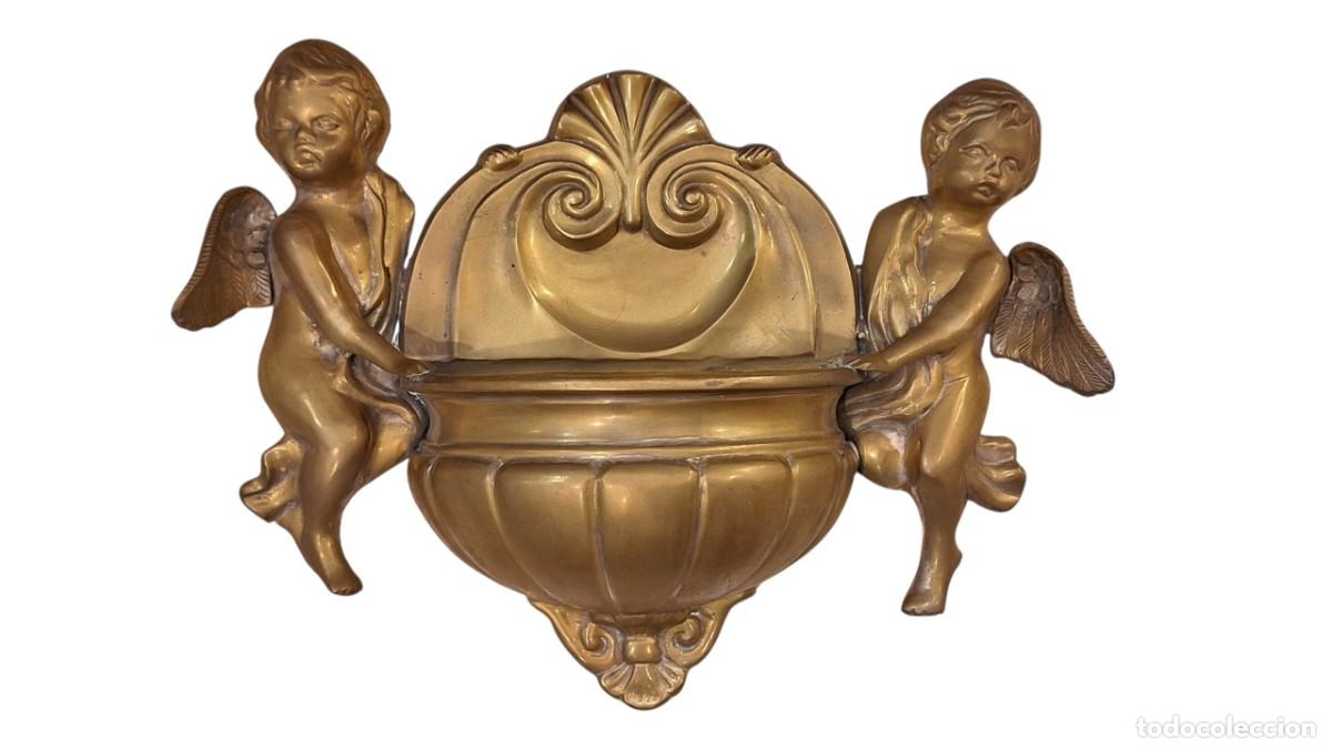 Antig&uuml;edades: Pila de agua bedita con dos &aacute;ngeles. Benditera. Bronce. Siglo XX. 27,5 x 37 x 10 cm.