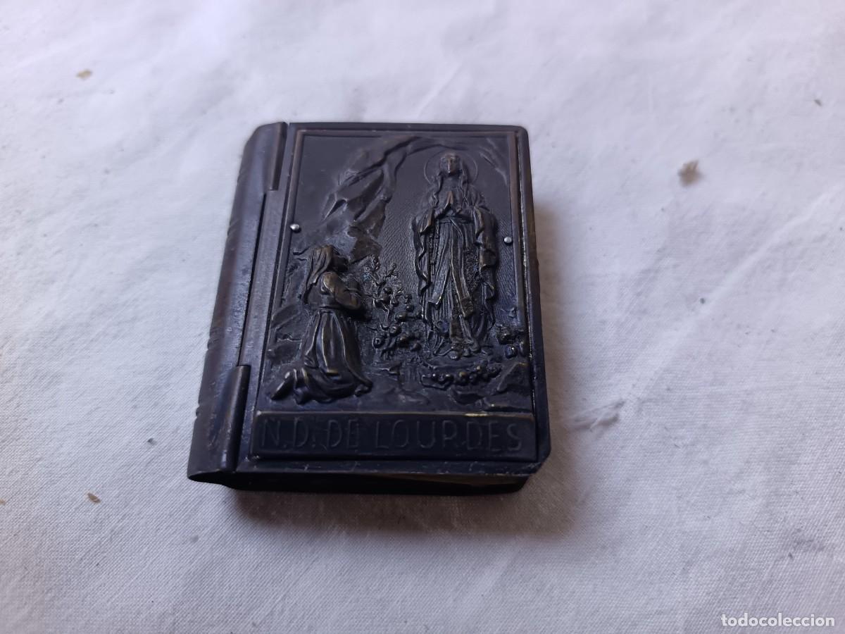 Antiquit&auml;ten: Peque&ntilde;a Caja de metal con forma de libro, con escena religiosa en relieve, N. D. de Lourdes