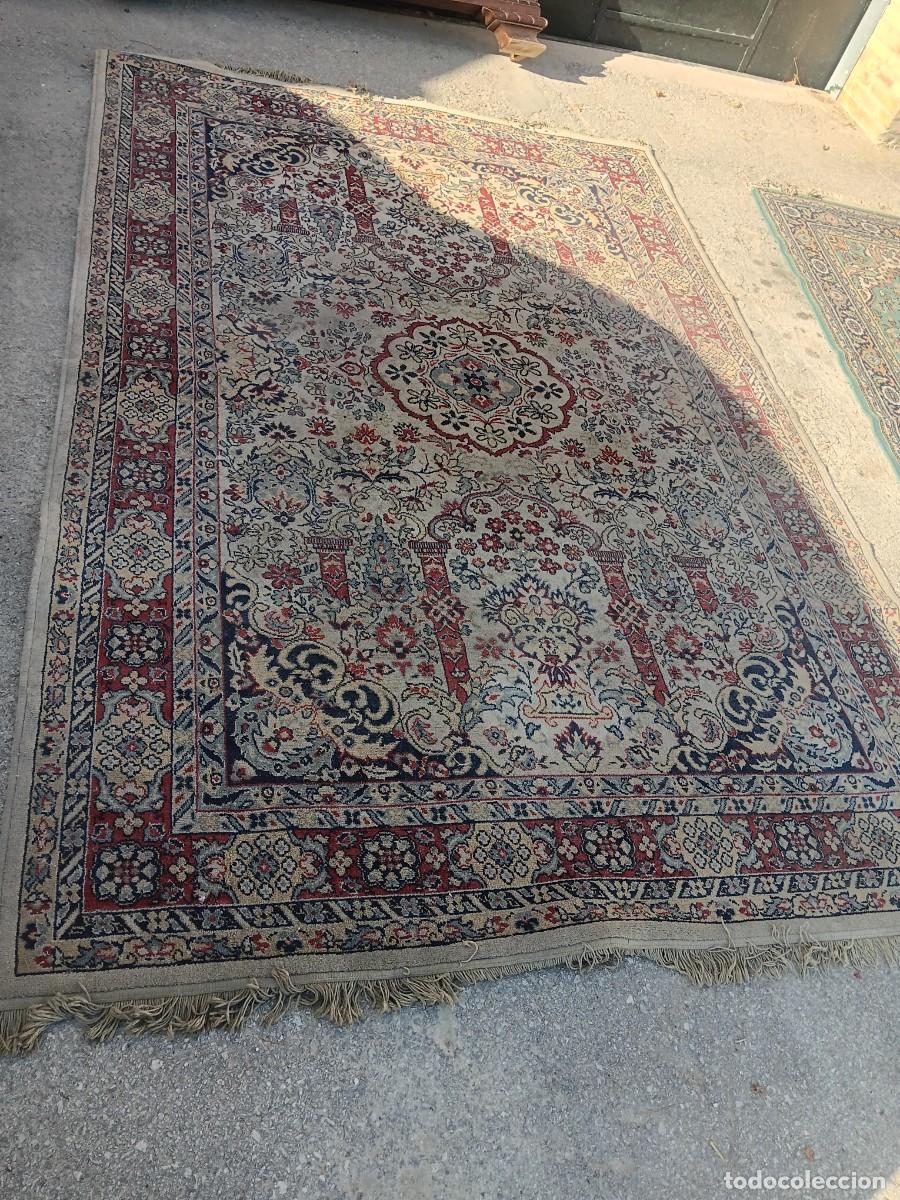 Antig&uuml;edades: alfombra persa de lana presenta un dise&ntilde;o detallado con un medall&oacute;n central floral y bordes rojos y