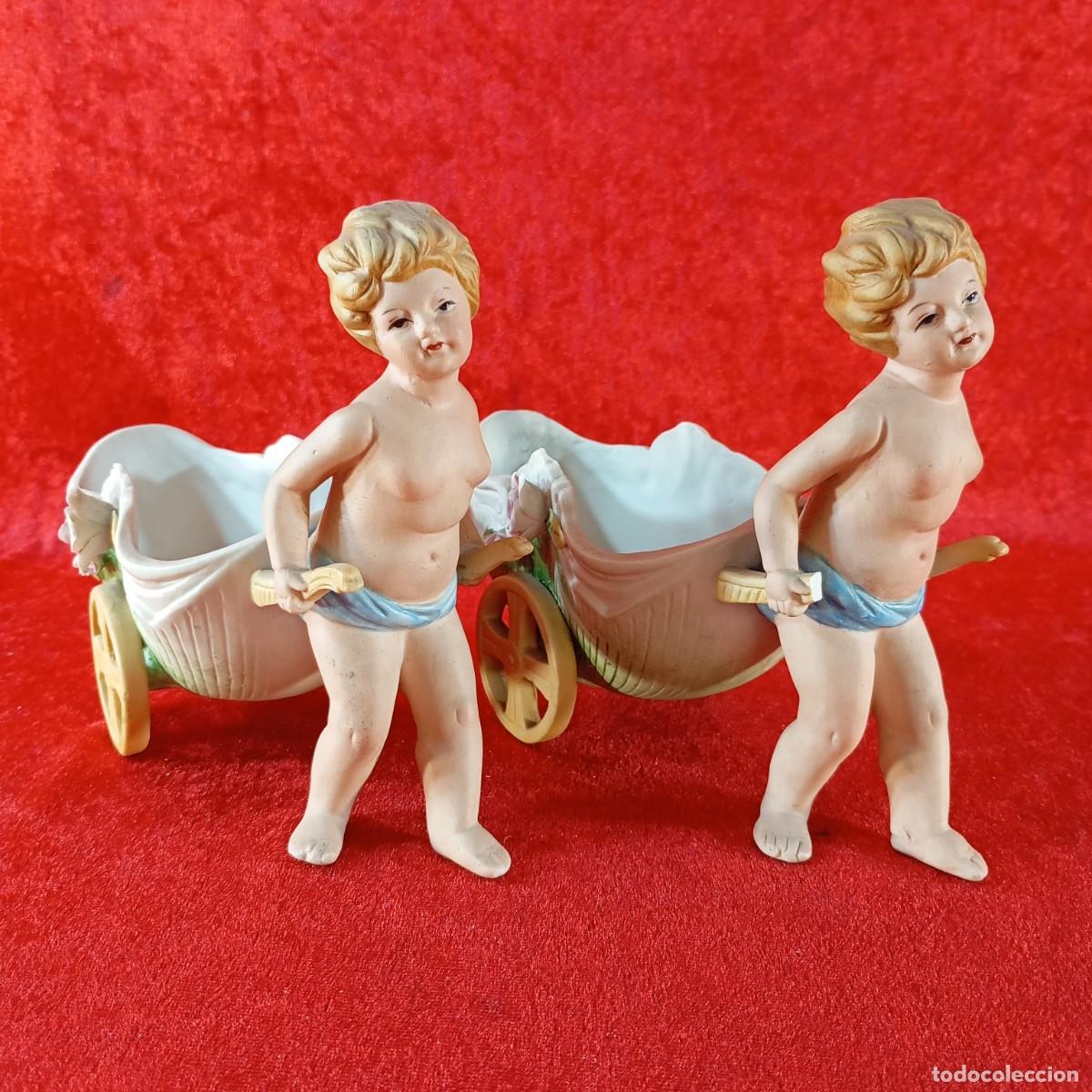 Antig&uuml;edades: LOTE 2 FIGURAD DE CERAMICA - QUERUBINES EMPUJANDO CARRETILLAS - 14,5 X 16 X 7,5 CM / 2210