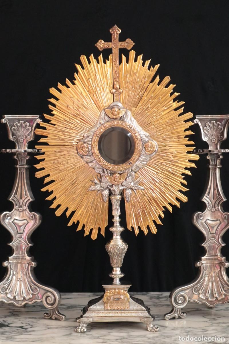 Antig&uuml;edades: Custodia de sol elaborada en metal plateado y dorado. Punzones de Meneses. Pps. S. XX. Mide 57 cm.