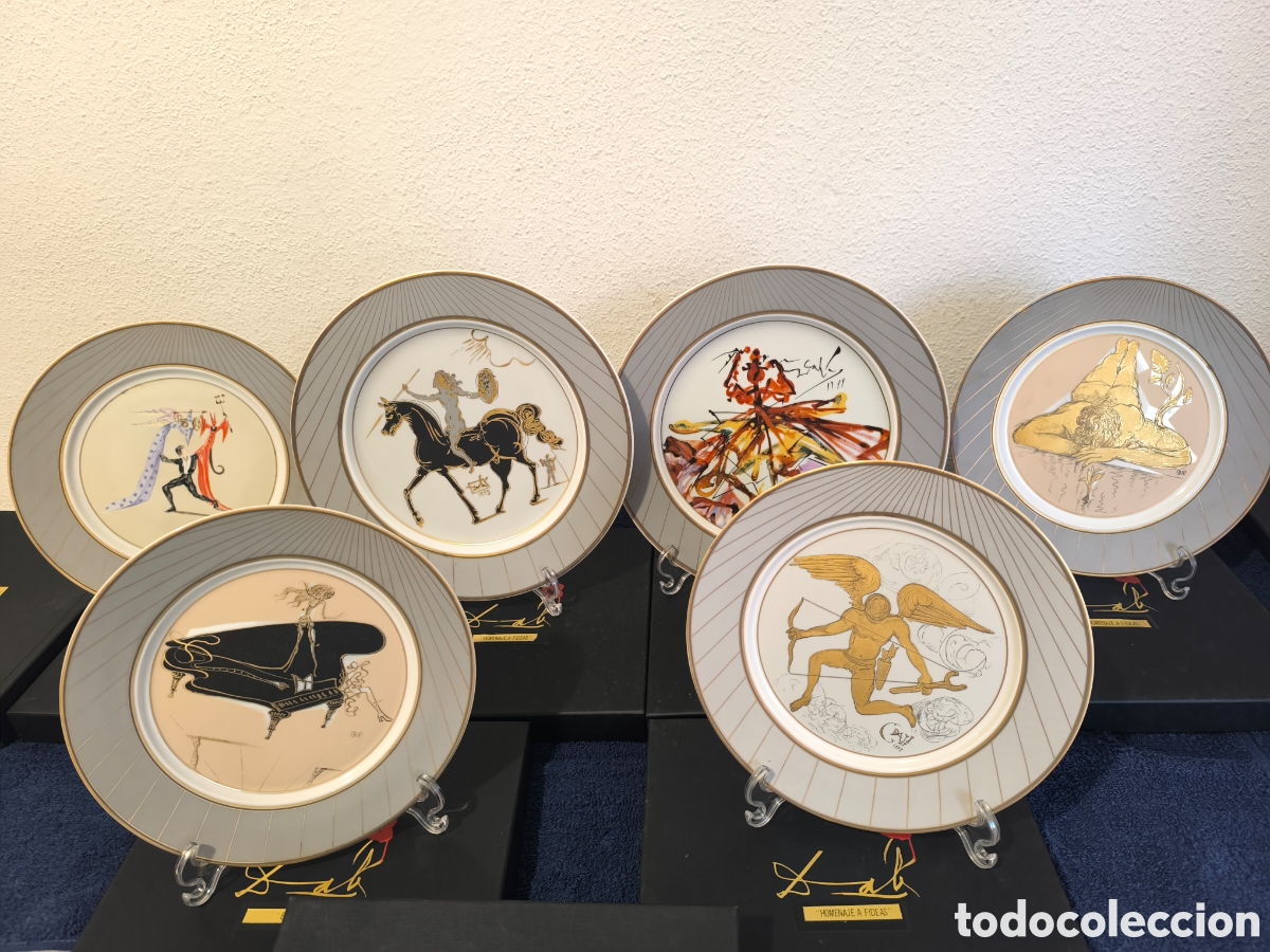 Antig&uuml;edades: Lote 7 plat&oacute;s 6 dise&ntilde;os diferentes, de Dali, bordados en oro de ley, con caja.