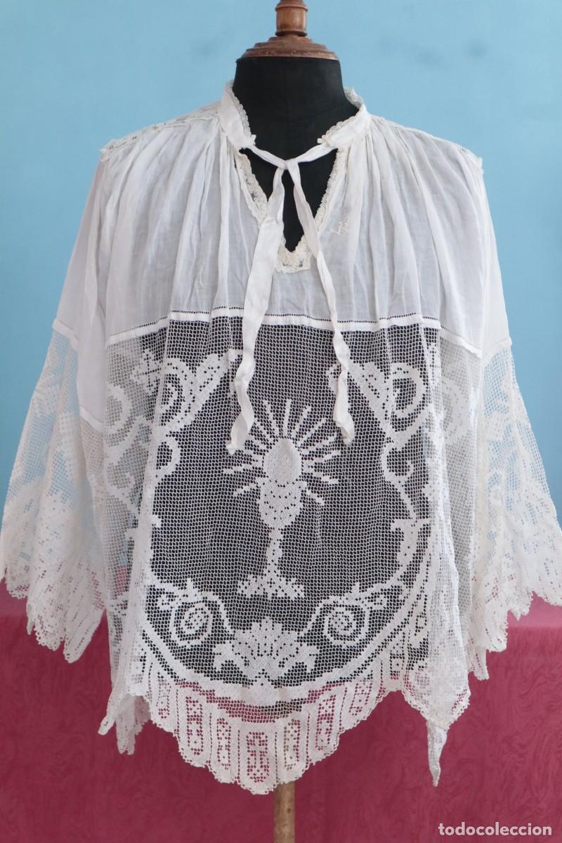 Antig&uuml;edades: Roquete de tama&ntilde;o natural confeccionado con encajes manuales en motivos religiosos. Pps. S. XX.
