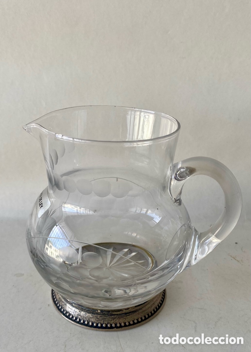 Antig&uuml;edades: Jarra de Cristal tallado y grabado y base de plata Primera mitad Siglo XX Motivos geom&eacute;tricos y uvas