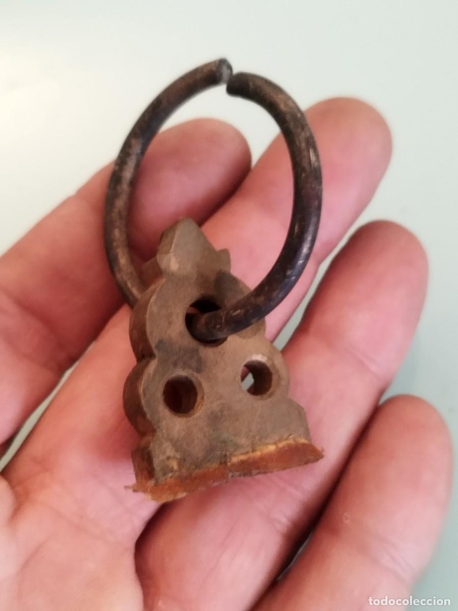 Antig&uuml;edades: Pieza de bronce o lat&oacute;n tipo tirador. Incompleta.