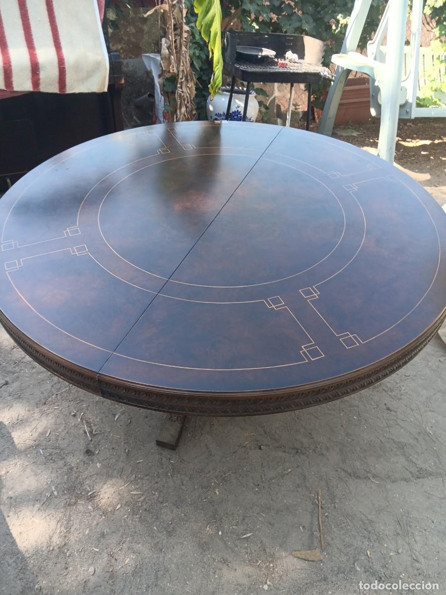 Antig&uuml;edades: mesa de comedor redonda y expansible radialmente (estilo Jupe) con un acabado oscuro y elegantes inc