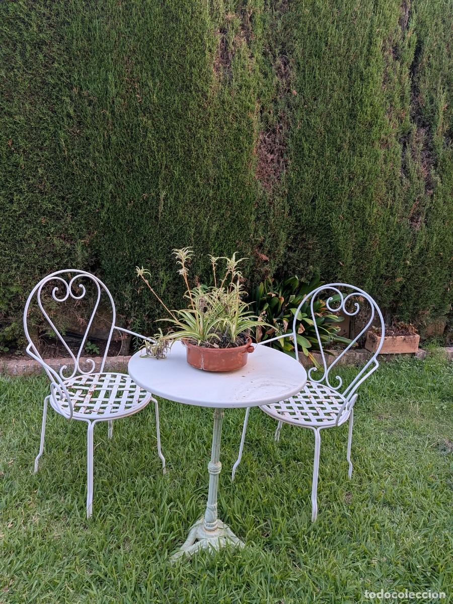 Antig&uuml;edades: Mesa con tapa de m&aacute;rmol y pie de hierro con dos sillass