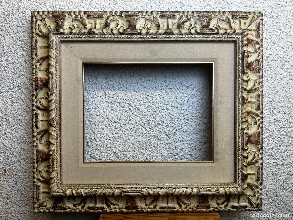 Antig&uuml;edades: Marco de madera con acabado blanco ocre desgastado y decoraci&oacute;n en relieve &ndash; segunda mitad del siglo