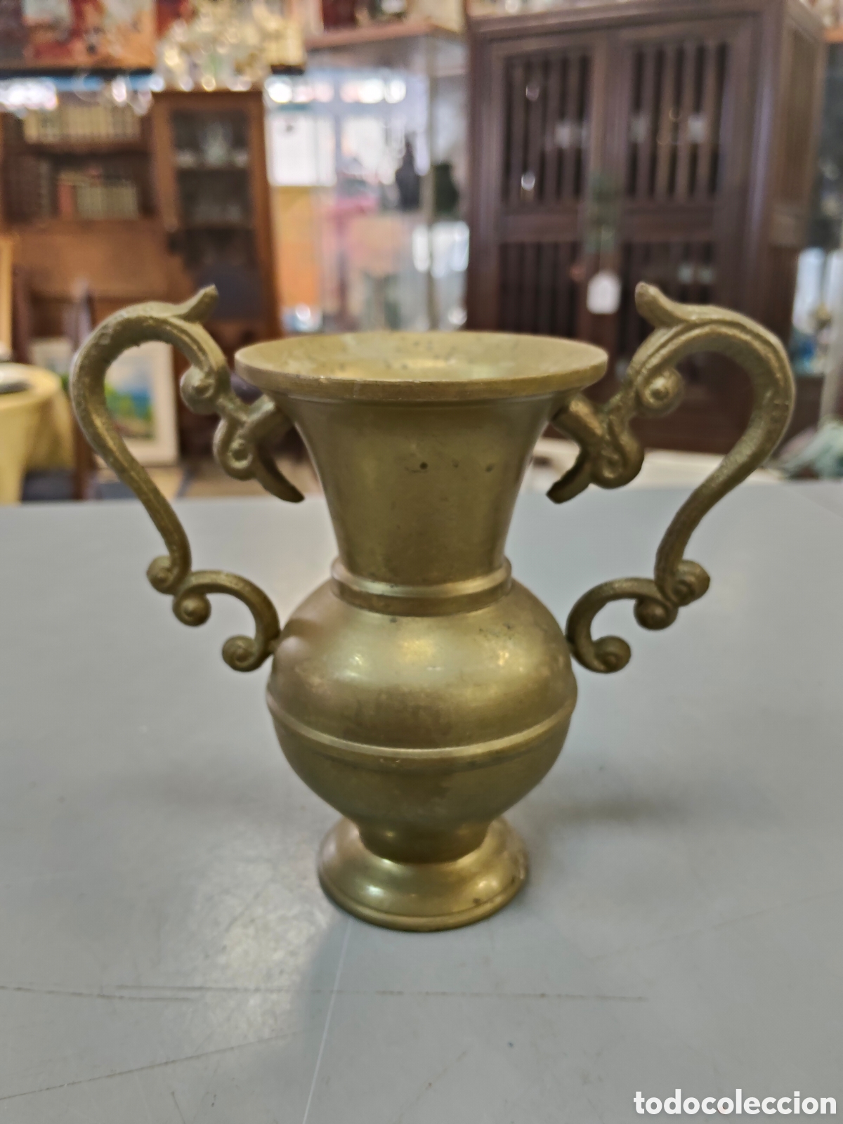 Antig&uuml;edades: &aacute;nfora peque&ntilde;a de bronce antiguo destaca por sus caracter&iacute;sticas asas laterales ornamentadas en form