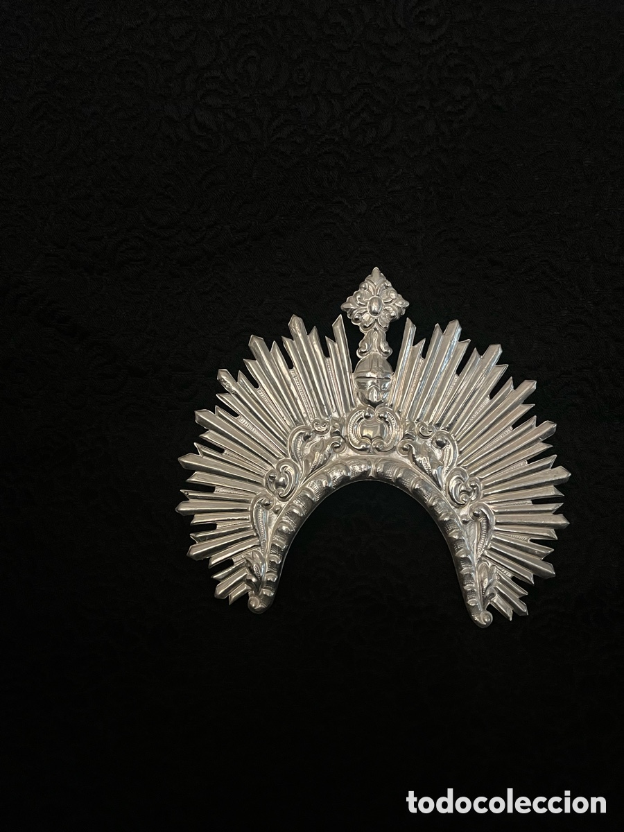 Antig&uuml;edades: Nimbo metal plateado. Mide 12 cm x 12 cm ; apertura interior 6 cm .