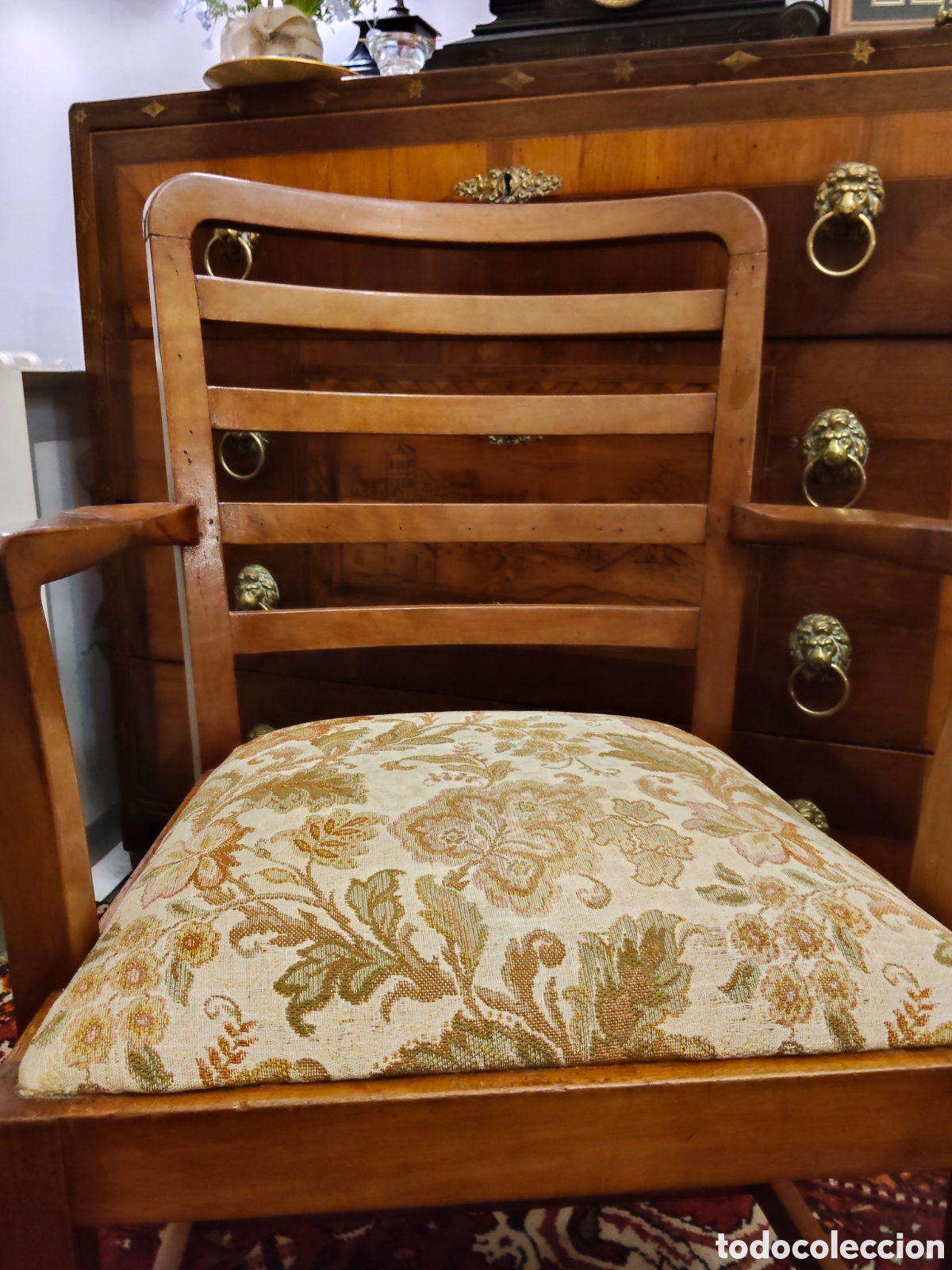 Antig&uuml;edades: sill&oacute;n antiguo de madera con un respaldo de listones horizontales y un asiento tapizado con un elega