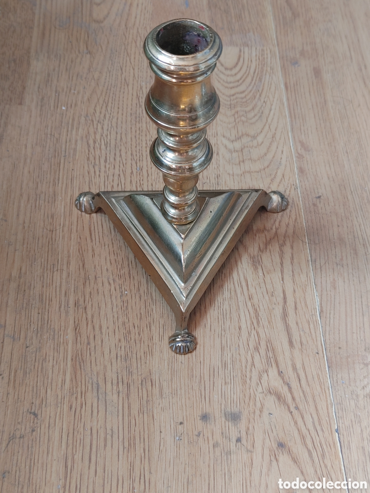 Antig&uuml;edades: Candelerito en bronce dorado. Con base triangular. Con patas de garra.S. XVIII.