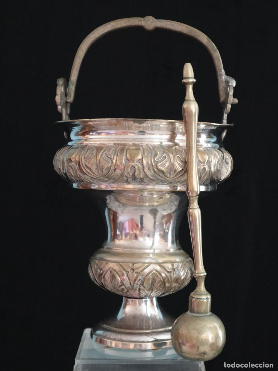 Antig&uuml;edades: Acetre e Hisopo lit&uacute;rgicos elaborados en metal plateado y repujado. S. XIX. Med: 22 cm.