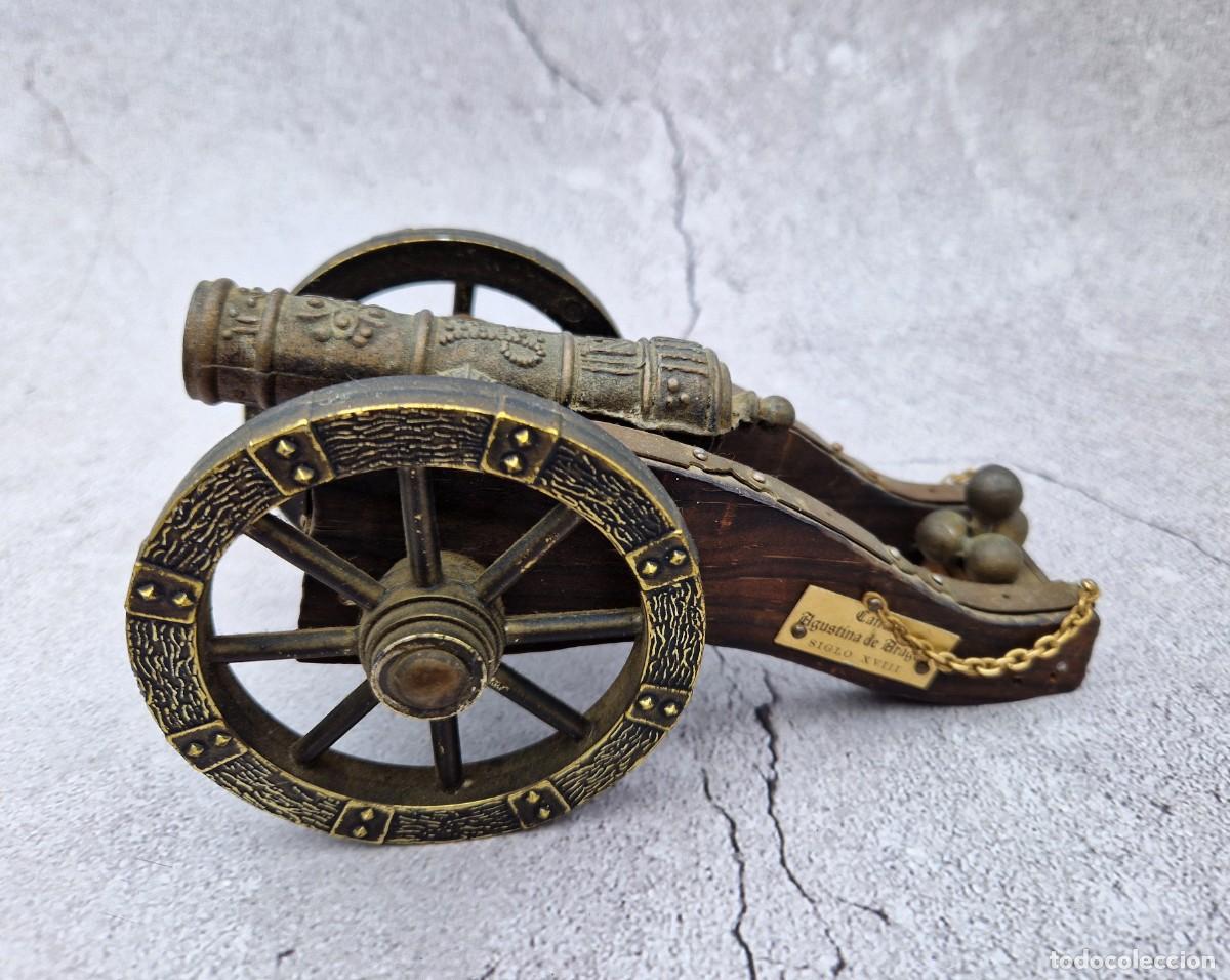 Antig&uuml;edades: A metal cannon with a pattern, a copy of the 18th century, a wooden toy made in Spain in Zaragoza.