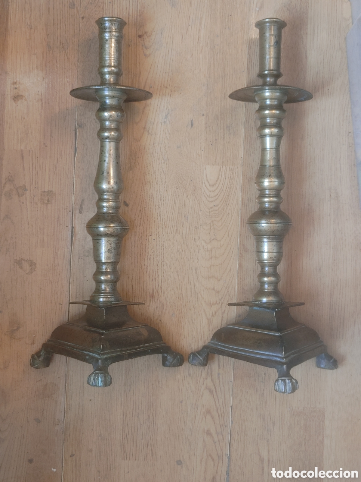 Antig&uuml;edades: Pareja de candeleros en bronce dorado. Con base triangular con patas de garra. S. XVIII.