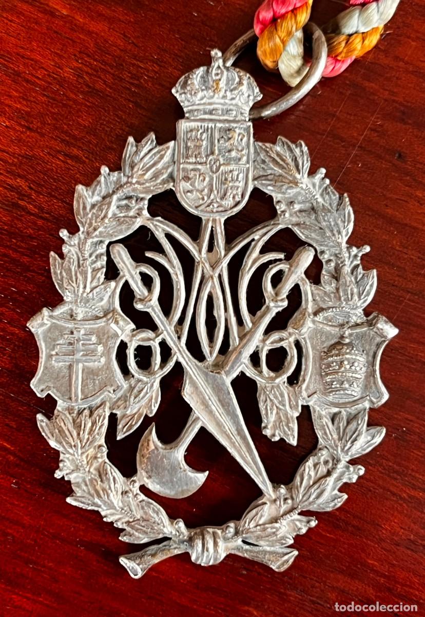 Antig&uuml;edades: Antigua medalla de Hermandad o Cofrad&iacute;a con cord&oacute;n tricolor, emblemas her&aacute;ldicos y atributos de la