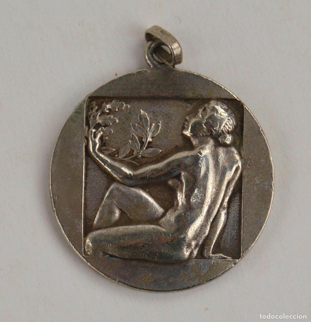 Antig&uuml;edades: Medalla o colgante con bajorrelieve, 1960's, mujer con rama, Martini & Rossi. 3,3 cm di&aacute;metro.