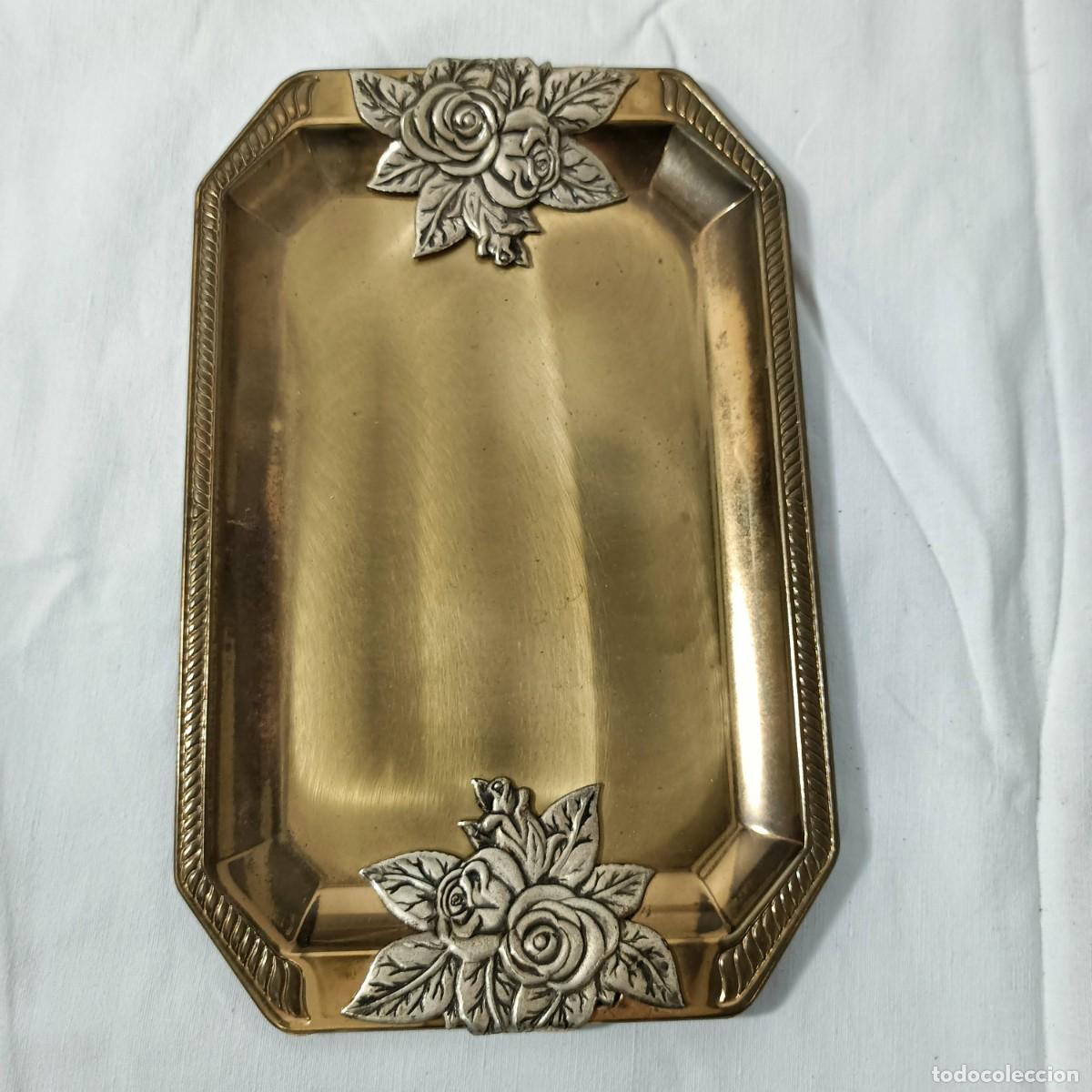 Antig&uuml;edades: Bandeja de metal color lat&oacute;n, bordes decorados con motivos florales en color plata.