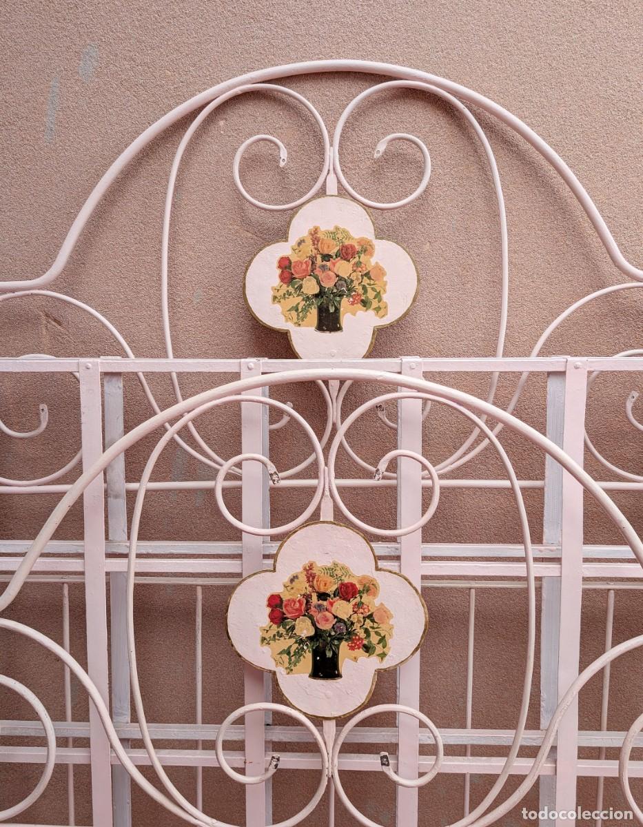 Antig&uuml;edades: Antigua cama de forja plegable con ruedas, s. XIX-pps XX. 2 flores decorativas de porcelana, 119 cm