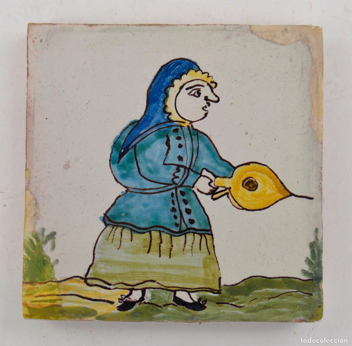 Antig&uuml;edades: Mujer con fuelle, azulejo de cer&aacute;mica catalana, serie Arts i Oficis, siglo XIX.