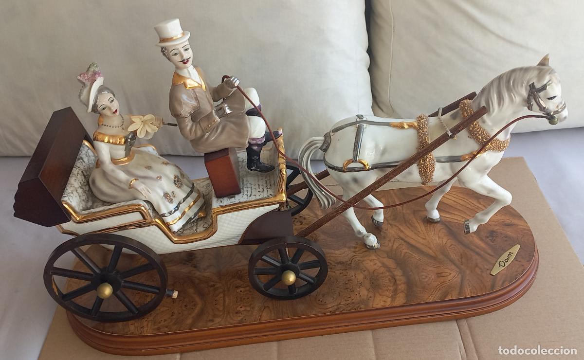 Antig&uuml;edades: Figura de porcelana, carruaje cl&aacute;sico con pareja y caballo sobre base de madera. Davor. 55 cm