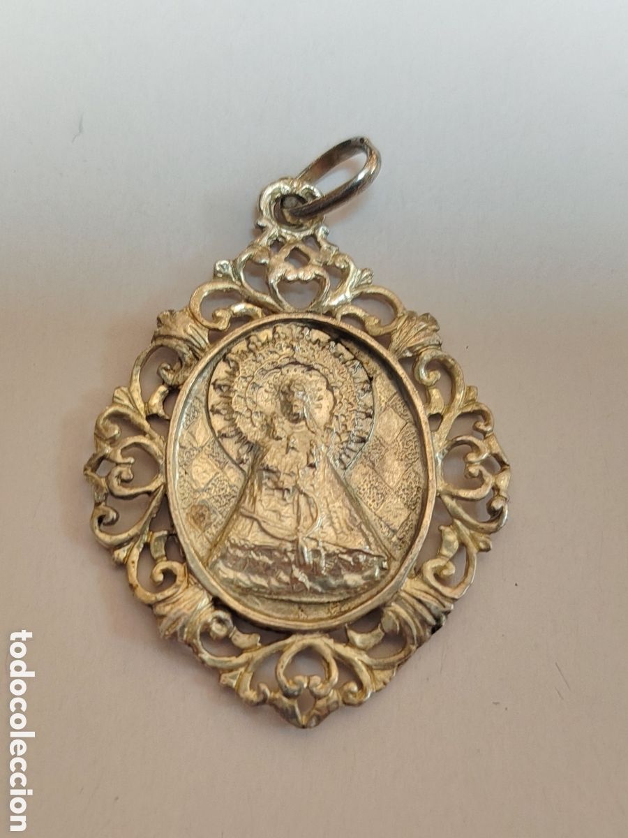 Antig&uuml;edades: Colgante de medalla religiosa ovalado con un marco de filigrana detallada que representa una advoca
