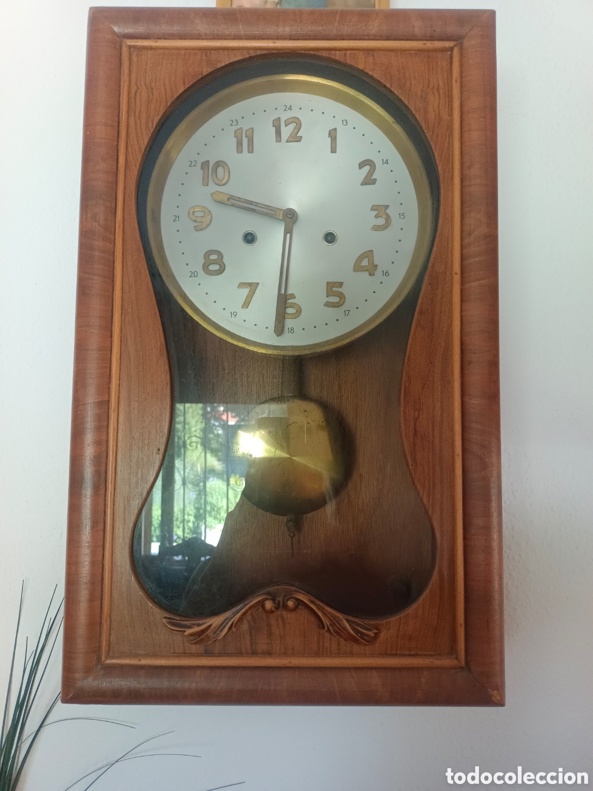 Antig&uuml;edades: Reloj de pared en mueble de madera.
