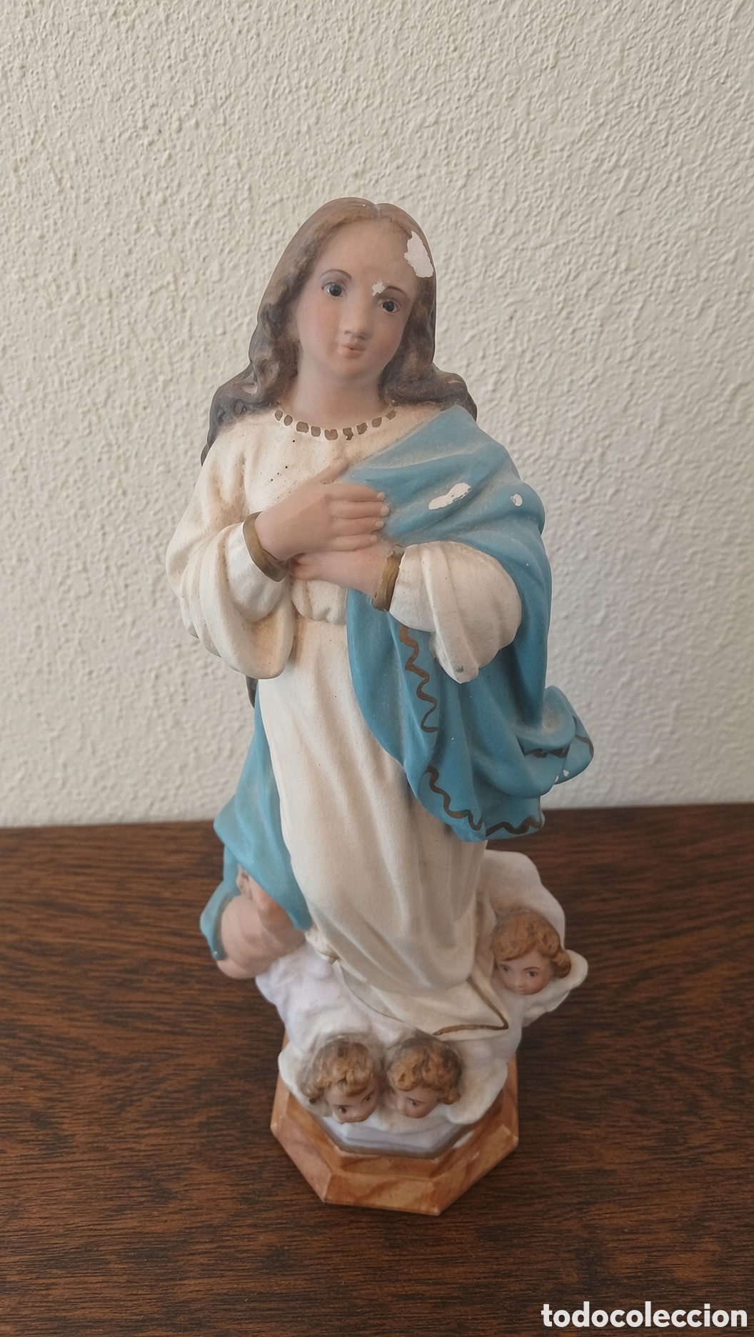 Antig&uuml;edades: Figura religiosa de la Virgen Mar&iacute;a arrodillada, acompa&ntilde;ada de cabezas de &aacute;ngeles.
