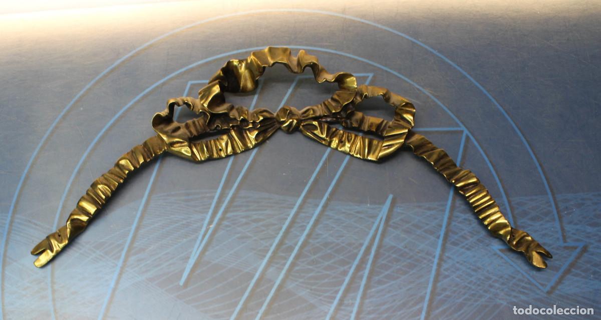Antig&uuml;edades: Detalle, aplique, copete de bronce dorado. Lazo.