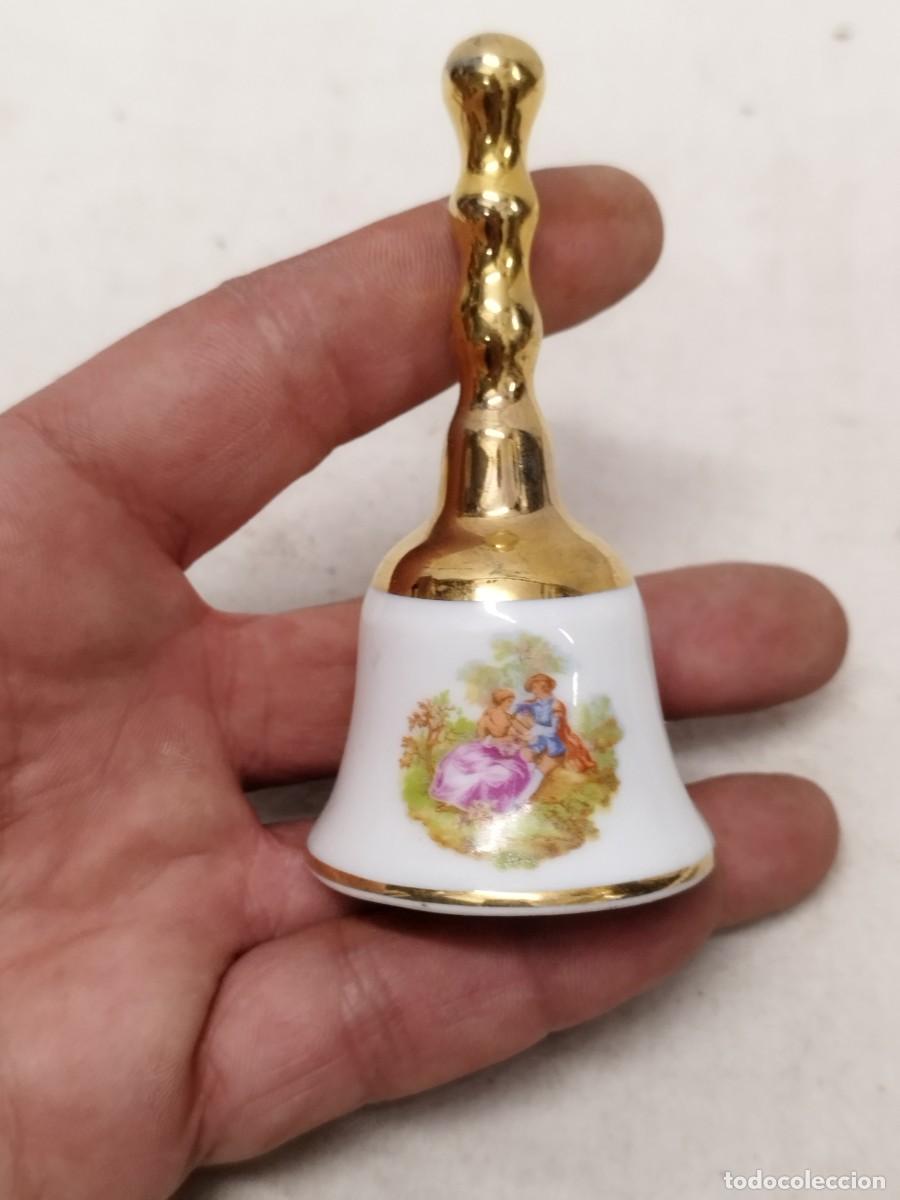 Antig&uuml;edades: Antigua campana de porcelana tipo limoges. Con gal&aacute;n y mujer, sin badajo.