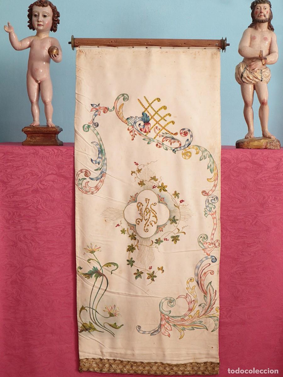 Antig&uuml;edades: Estandarte enrollable confeccionado en seda portando motivos religiosos. Pps. S. XX. Mide 90 x 39 cm