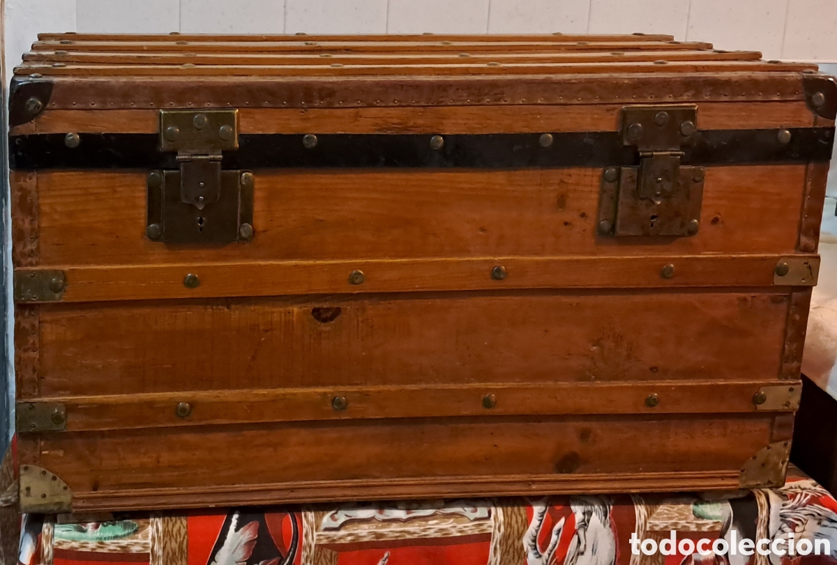 Antig&uuml;edades: Baul de viaje. En madera con listones y herrajes metalicos. Retapizado su interior.