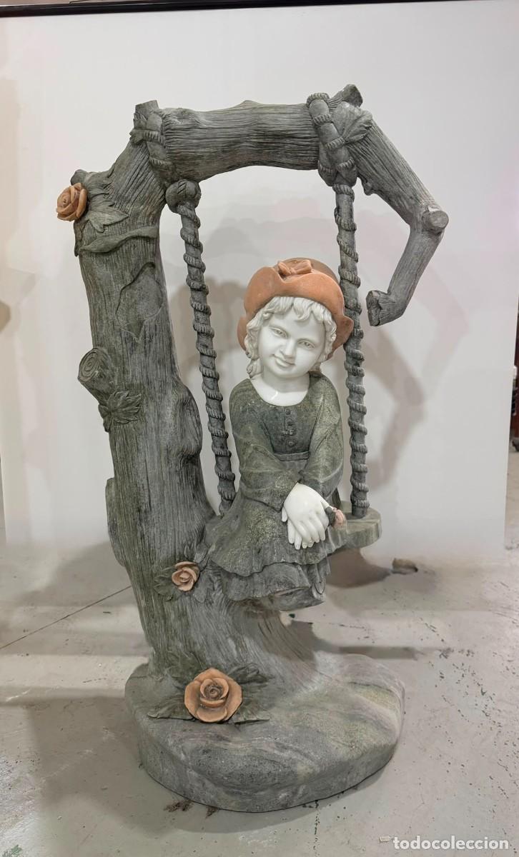 Antig&uuml;edades: Ni&ntilde;a sobre columpio tallada en m&aacute;rmol con combinaci&oacute;n de colores (verde, blanco y salm&oacute;n).