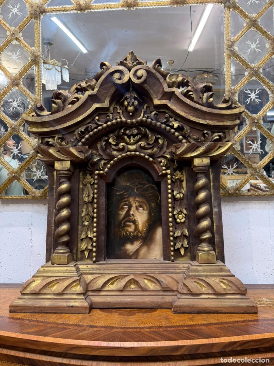 Antig&uuml;edades: Retablo tallado en madera con cristo pintado sobre madera y columnas salom&oacute;nicas a los lados.