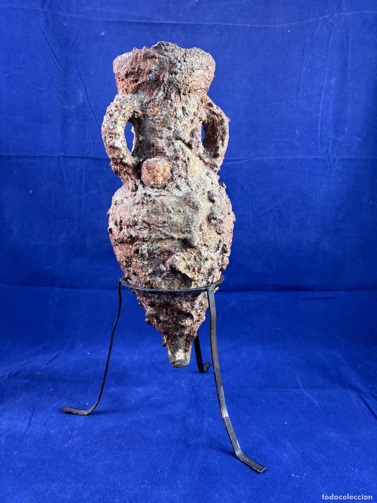 Antig&uuml;edades: &Aacute;nfora romana de cer&aacute;mica con incrustaciones marinas y soporte de hierro. Decorativa 26 cm