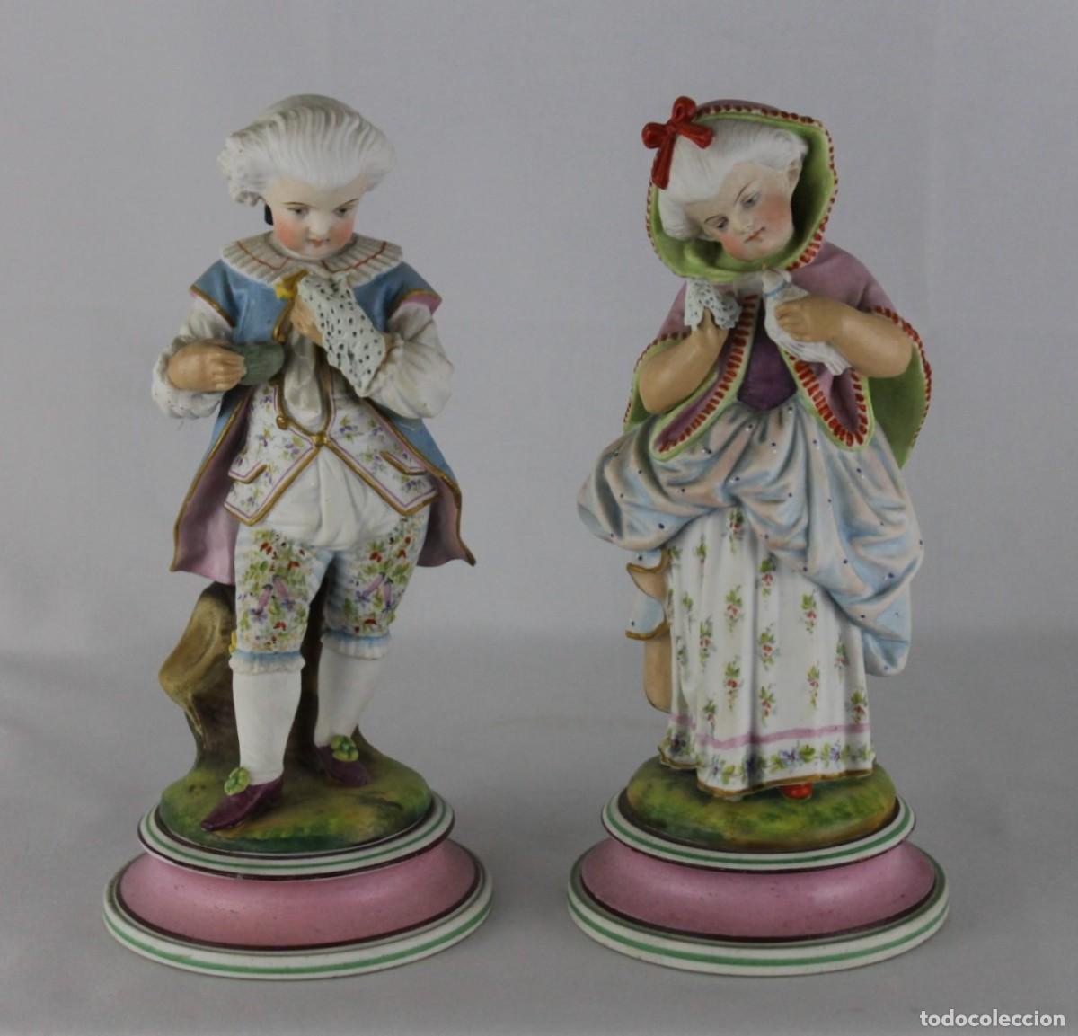 Antig&uuml;edades: Pareja de figuras de porcelana policromada. Dama y caballero de &eacute;poca. Numeradas y sello HC