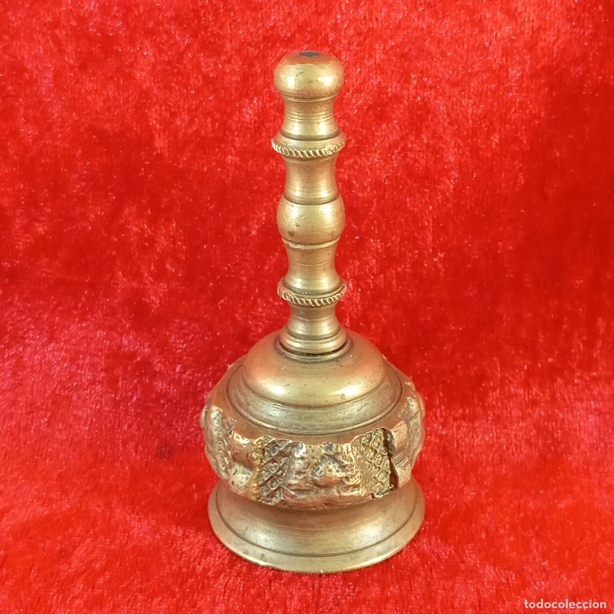 Antig&uuml;edades: ANTIGUA CAMPANA DE MANO - FABRICADA EN LAT&Oacute;N DE RELIEVE TALLADO - SIGLO XX - 8 CM DE ALTO - 33
