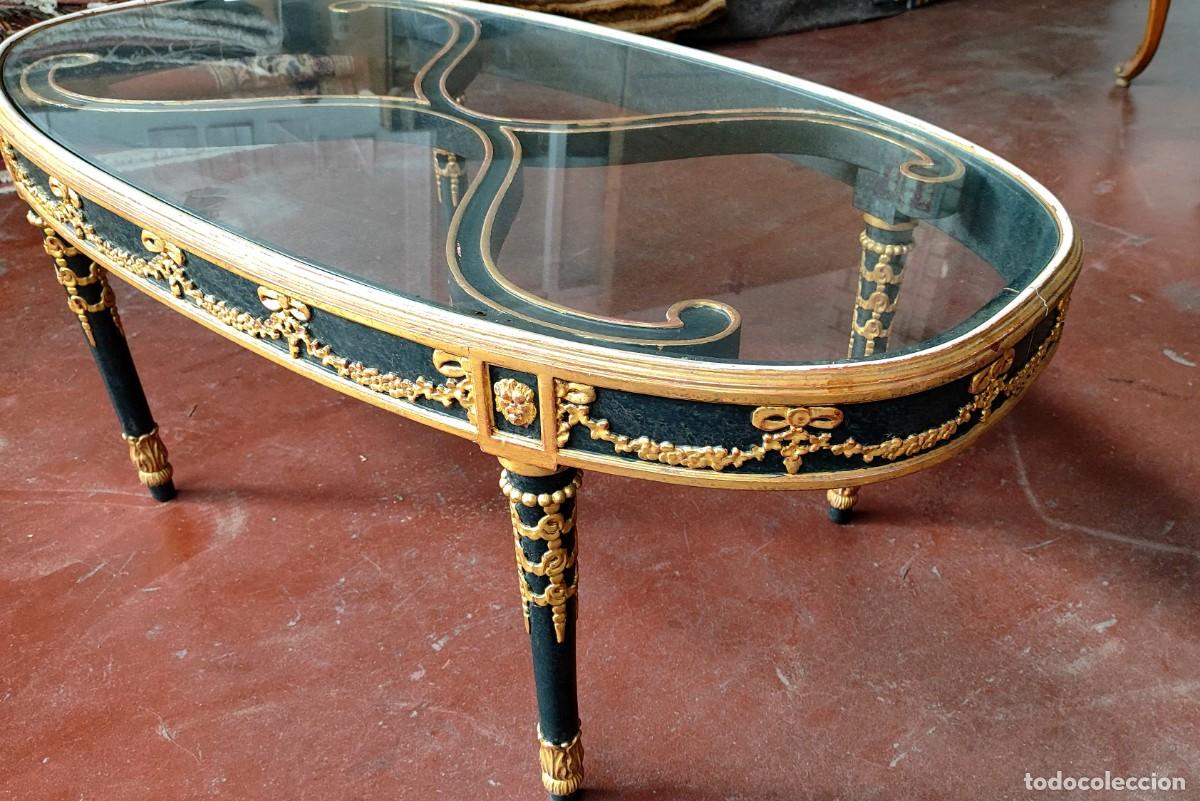 Antig&uuml;edades: Mesa de centro ovalada en madera tallada, lacada en negro y dorado. Con tapa en cristal.