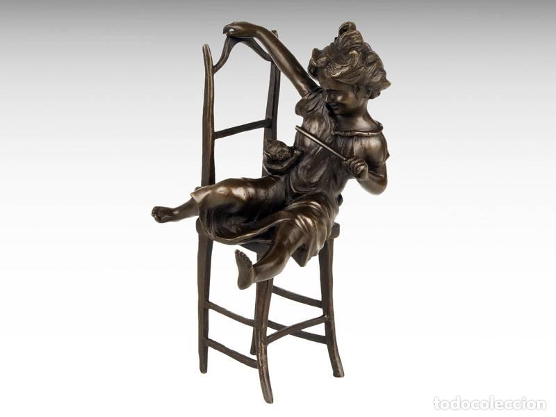 Arte: Escultura de bronze - Menina sentada na cadeira brincando com o seu gato (1098)