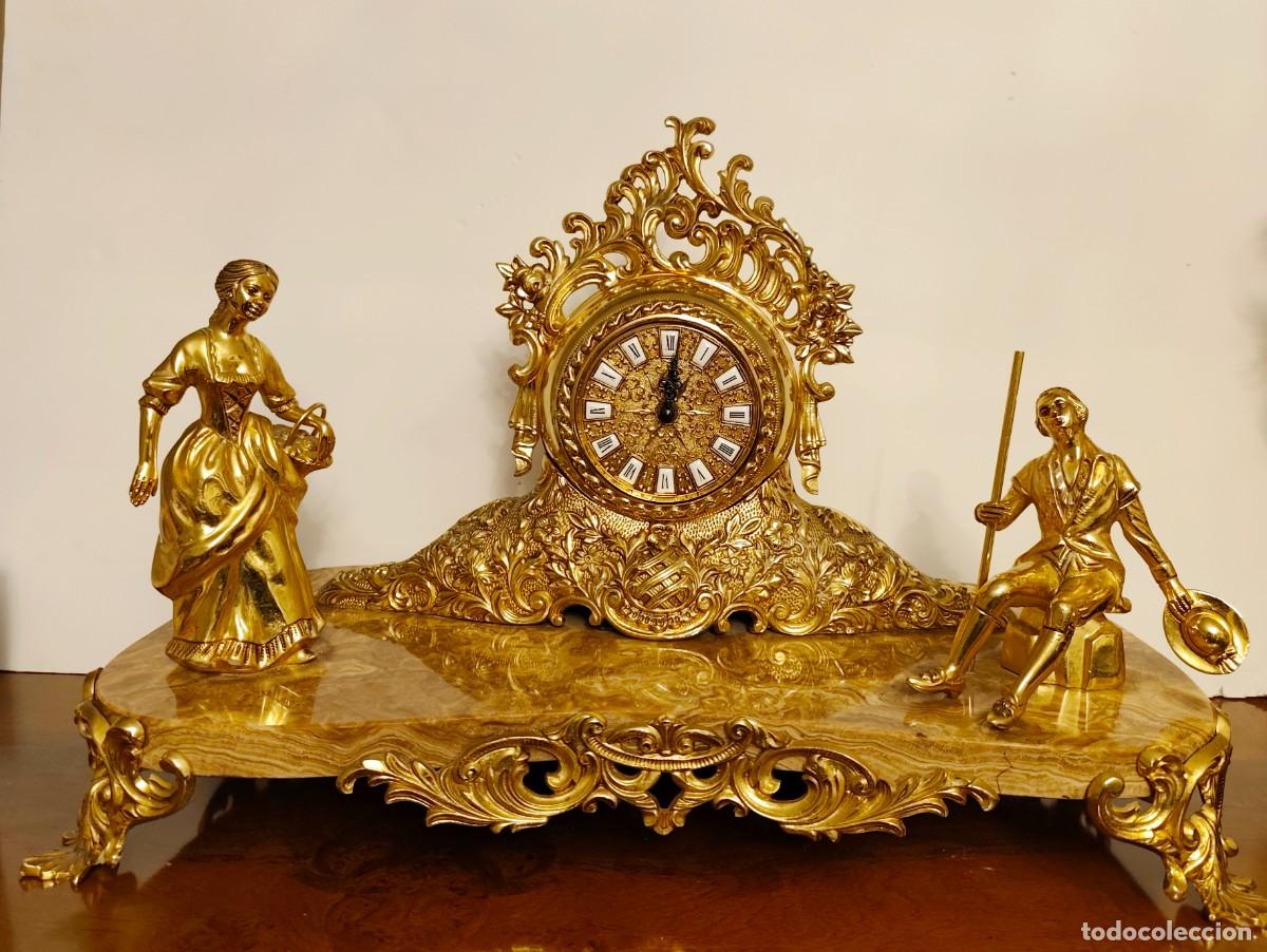 Arte: Garnitura de sal&oacute;n compuesta por reloj de sobremesa y dos candelabros con base de m&aacute;rmol
