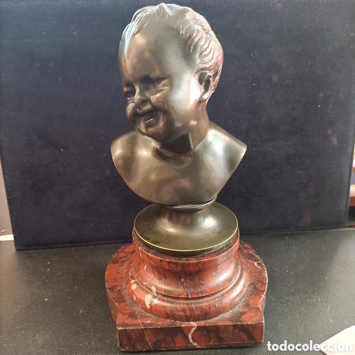 Arte: Busto en bronce de ni&ntilde;o riendo.